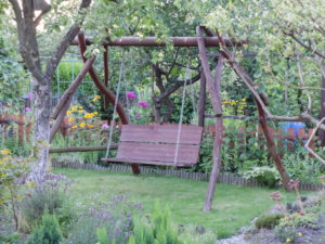 Selbstgebaute Hollywoodschaukel aus massiven Baumstämmen im Garten Selbstgebaute Hollywoodschaukel aus massiven Baumstämmen im Garten
