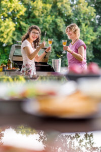 Young woman and mother have fun, laugh, barbecue, toasting Young woman and mother have fun, laugh, barbecue, toasting
