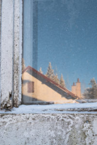 Snow-covered, old windowpane with reflection of a sunny, wintry landscape and hut in the Vosges, France Snow-covered, old windowpane with reflection of a sunny, wintry landscape and hut in the Vosges, France