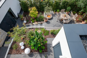Overview of a neat garden landscape with a terrace, plant beds and access paths Overview of a neat garden landscape with a terrace, plant beds and access paths