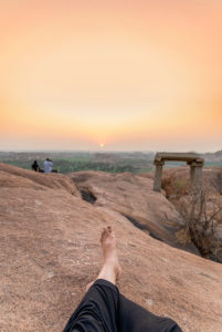 Legs of the photographer relaxing in the evening on a rock Legs of the photographer relaxing in the evening on a rock