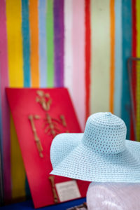 Anonymous lady with a floppy hat looks at a monkey skeleton on a striped wall Anonymous lady with a floppy hat looks at a monkey skeleton on a striped wall