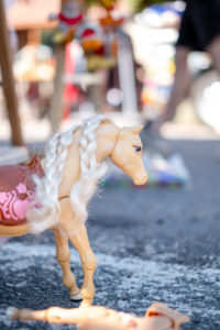 A toy horse stands on asphalt on a flea market A toy horse stands on asphalt on a flea market