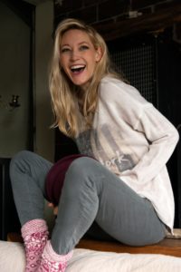 Blond woman sitting laughing in the living room Blond woman sitting laughing in the living room