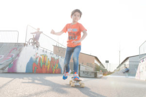 Boy in the orange T-shirt riding skateboard Boy in the orange T-shirt riding skateboard