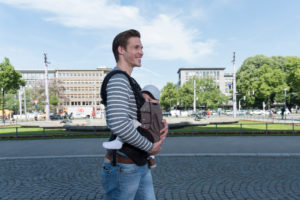 Father carries baby in the baby carrier and go for a walk Father carries baby in the baby carrier and go for a walk