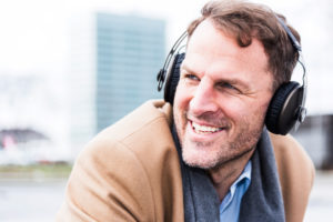 Businessman hears outside music with earphones, portrait Businessman hears outside music with earphones, portrait