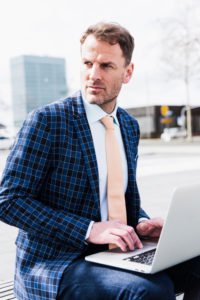 Businessman outside with laptop, half portrait Businessman outside with laptop, half portrait