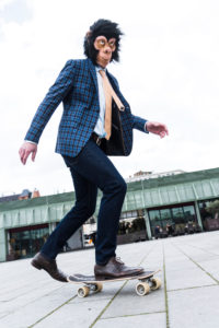 Businessman with monkey mask on skateboard Businessman with monkey mask on skateboard