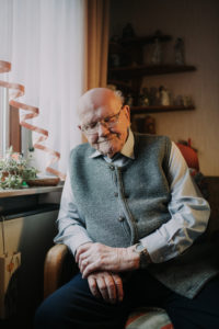 Old man sits tiredly in front of the window