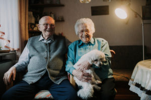 older couple with poodle in own home