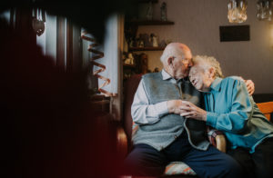 older couple are cuddling in the living room