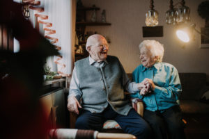 older couple sits laughingly in the living room older couple sits laughingly in the living room