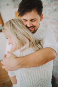 Young man embraces young woman, half portrait