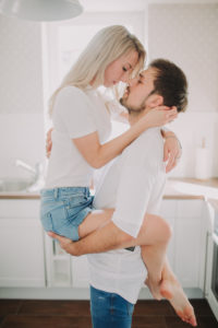 Young man carries young woman, half profile