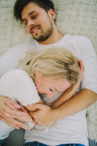 Young couple in love at home in the bed, half portrait