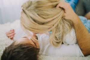 Young loving couple at home in bed, close up