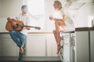 Young couple in love making music at home, 
