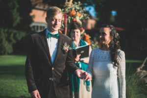 Alternate bridal couple at spiritual wedding ceremony outdoors, half portrait