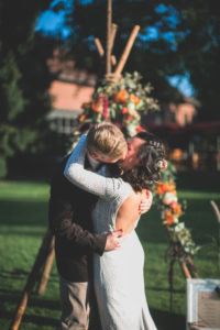 Alternate bridal couple outside, embrace, kiss
