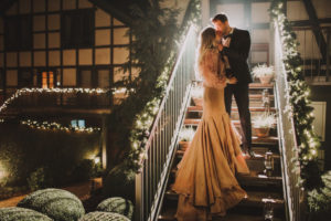 Bridal couple stand on a staircase and kiss each other