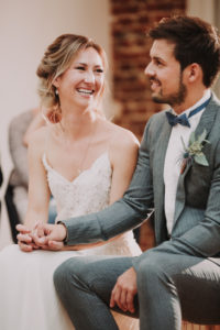 Bridal couple, sitting, holding hands, smiling,