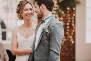 Bridal couple, standing, eye contact, smiling, half portrait, detail,