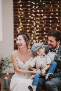 Bridal couple and boy, sitting, having fun,