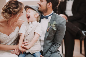 Bridal couple and boy, sitting, having fun,