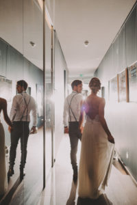 Bridal couple go down a hallway, back view,