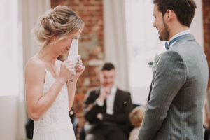Bride and groom, standing, bridal vow, reading, reading, laughing,