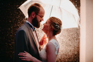 happy bride and groom under umbrella