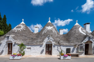 Alberobello, Bari province, Salento, Puglia, Italy, Europe. The typical trulli houses with their cone-shaped roof and the symbols