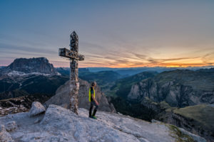 Gardena Pass, Bolzano Province, South Tyrol, Italy. A mountaineer at the summit of the Große Cirspitze admires the sunset Gardena Pass, Bolzano Province, South Tyrol, Italy. A mountaineer at the summit of the Große Cirspitze admires the sunset