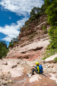 Aldein, Province of Bolzano, South Tyrol, Italy. Geoparc Bletterbach. A hiker in the Bletterbach Gorge Aldein, Province of Bolzano, South Tyrol, Italy. Geoparc Bletterbach. A hiker in the Bletterbach Gorge
