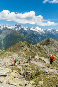 Sand in Taufers, Provinz Bozen, Südtirol, Italien. Wanderer auf dem Panoramaweg im Wandergebiet Speikboden. Im Hintergrund die Zillertaler Alpen mit den Gipfeln Schwarzenstein und Grosser Löffler Sand in Taufers, Provinz Bozen, Südtirol, Italien. Wanderer auf dem Panoramaweg im Wandergebiet Speikboden. Im Hintergrund die Zillertaler Alpen mit den Gipfeln Schwarzenstein und Grosser Löffler