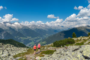 Sand in Taufers, Provinz Bozen, Südtirol, Italien. Wanderer auf dem Panoramaweg im Wandergebiet Speikboden mit Blick in das Ahrntal und den Zillertaler Alpen Sand in Taufers, Provinz Bozen, Südtirol, Italien. Wanderer auf dem Panoramaweg im Wandergebiet Speikboden mit Blick in das Ahrntal und den Zillertaler Alpen