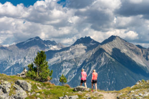 Sand in Taufers, Provinz Bozen, Südtirol, Italien. Wanderer auf dem Panoramaweg im Wandergebiet Speikboden mit Blick zur Rieserfernergruppe mit den Gipfeln Schneebiger Nock, Fensterleekofel und Windschar. Sand in Taufers, Provinz Bozen, Südtirol, Italien. Wanderer auf dem Panoramaweg im Wandergebiet Speikboden mit Blick zur Rieserfernergruppe mit den Gipfeln Schneebiger Nock, Fensterleekofel und Windschar.