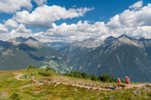 Sand in Taufers, Provinz Bozen, Südtirol, Italien. Wanderer auf dem Panoramaweg im Wandergebiet Speikboden. Im Hintergrund links ddie Durreckgruppe und rechts die Rieserfernegruppe Sand in Taufers, Provinz Bozen, Südtirol, Italien. Wanderer auf dem Panoramaweg im Wandergebiet Speikboden. Im Hintergrund links ddie Durreckgruppe und rechts die Rieserfernegruppe