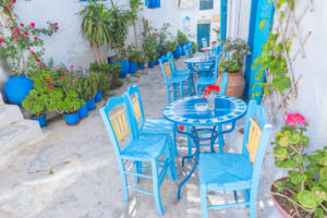 Streetside cafe tables and chairs, Amorgos, Cyclades Islands, Greece, Europe Streetside cafe tables and chairs, Amorgos, Cyclades Islands, Greece, Europe
