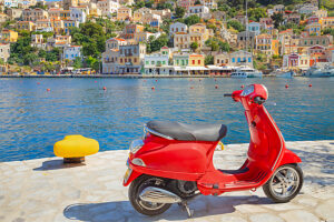 Red vespa scooter parked at Gialos harbour, Gialos, Symi Island, Dodecanese Islands, Greece