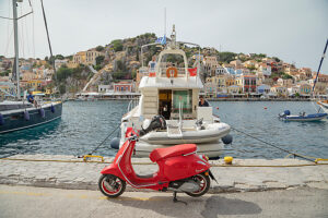 Red vespa scooter parked at Gialos harbour, Gialos, Symi Island, Dodecanese Islands, Greece