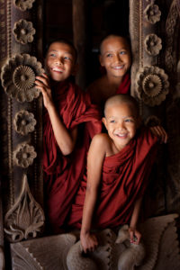 Three young novice monks in Shwenandaw monastery near Mandalay, Myanmar