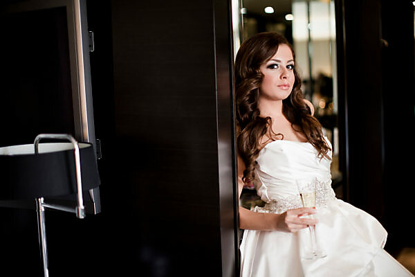 Bildagentur | mauritius images | Portrait of young woman in wedding gown,  holding glass of champagne and looking at camera, Ontario, Canada