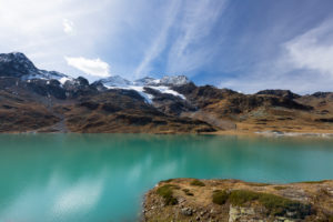 Despite the clouds of fog, there is a perfect autumn day on the Ospizio Bernina with the Lago Bianco in the foreground, canton of Grisons, Switzerland Despite the clouds of fog, there is a perfect autumn day on the Ospizio Bernina with the Lago Bianco in the foreground, canton of Grisons, Switzerland