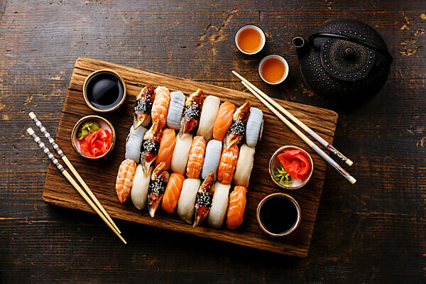 Sushi Set nigiri sashimi and sushi rolls on wooden serving board