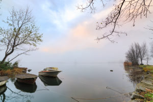 Boats moored framed by mist of autumn at dawn Pozzo di Riva Novate Mezzola Chiavenna Valley Lombardy Italy Europe Boats moored framed by mist of autumn at dawn Pozzo di Riva Novate Mezzola Chiavenna Valley Lombardy Italy Europe