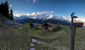 Panorama of huts and valley framed by snowy peaks at dawn Tombal Soglio Bregaglia Valley canton of Graubünden Switzerland Europe Panorama of huts and valley framed by snowy peaks at dawn Tombal Soglio Bregaglia Valley canton of Graubünden Switzerland Europe
