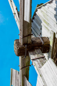 Detail des Drehkeuzes einer Bockwindmühle vor blauem Himmel Detail des Drehkeuzes einer Bockwindmühle vor blauem Himmel