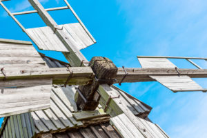 Detail des Drehkeuzes einer Bockwindmühle vor blauem Himmel Detail des Drehkeuzes einer Bockwindmühle vor blauem Himmel